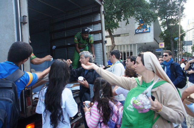 Foodstuff distribution to pilgrims on Rio Branco, walking to Copacabana for the final mass